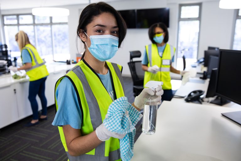 Cleaning staff wearing gloves and protective clothing in a facility
