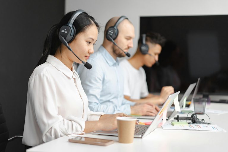 Customer service representatives wearing headsets at computers