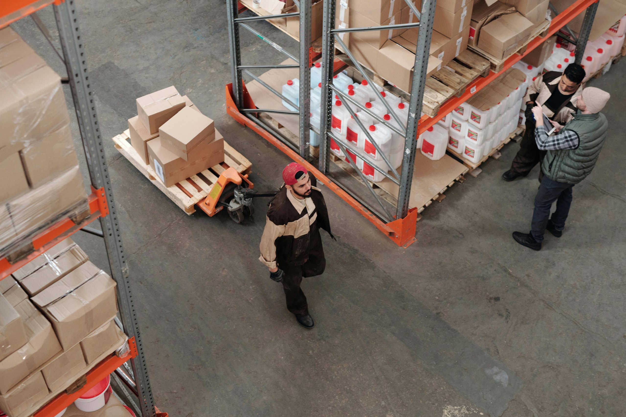 Warehouse worker moving boxed goods with a pallet jack